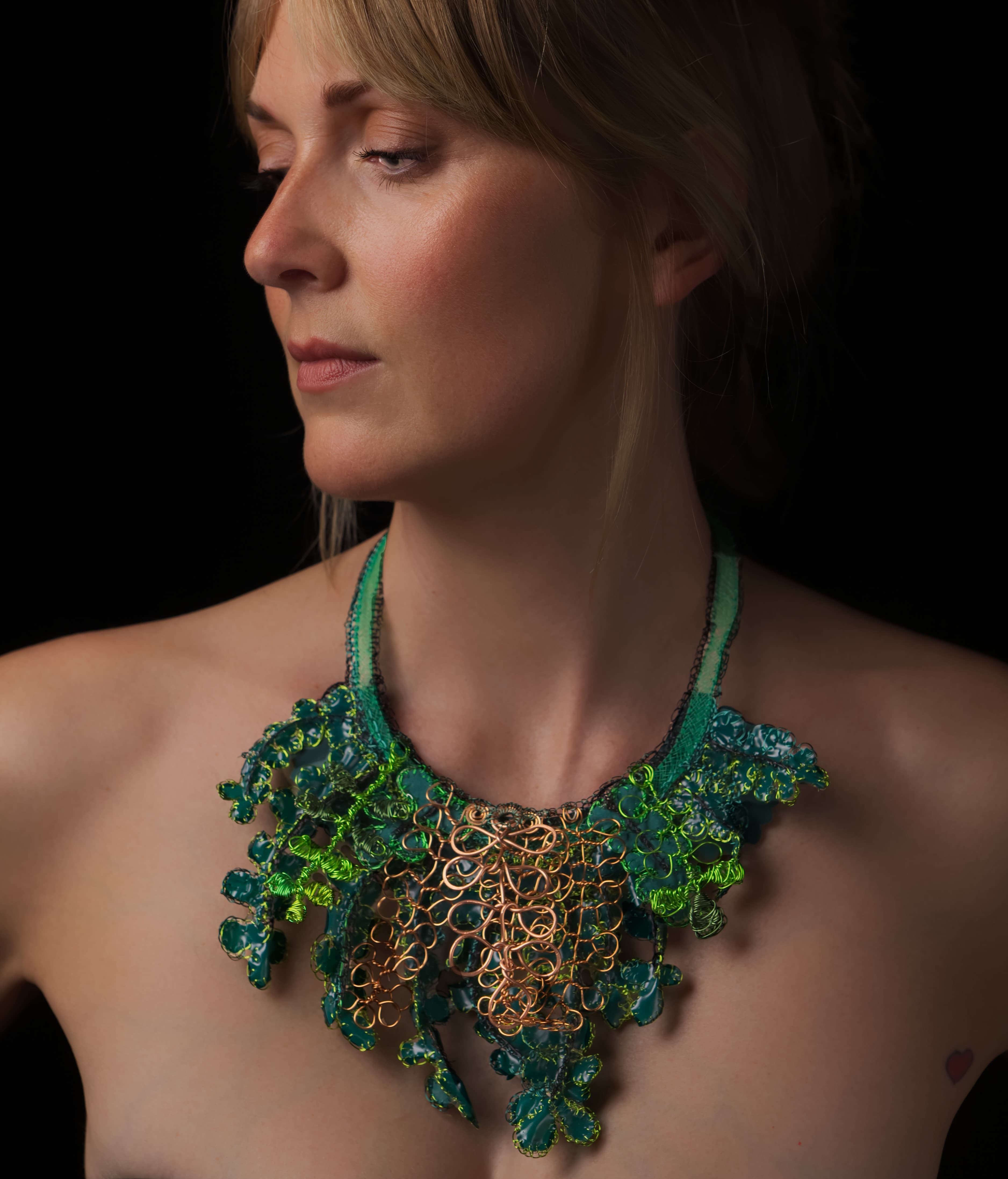 Picture of a model wearing a necklace made out of recyled materials